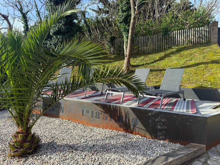 Espace extérieur moderne avec salon de jardin, pergola et aménagement paysager.