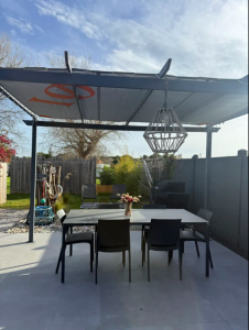 Terrasse équipée d’une table, chaises et transats pour des repas en extérieur à l’île d’Oléron.