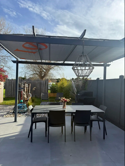 Terrasse équipée d’une table, chaises et transats pour des repas en extérieur à l’île d’Oléron.