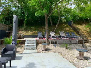 Espace extérieur moderne avec salon de jardin, pergola et aménagement paysager.