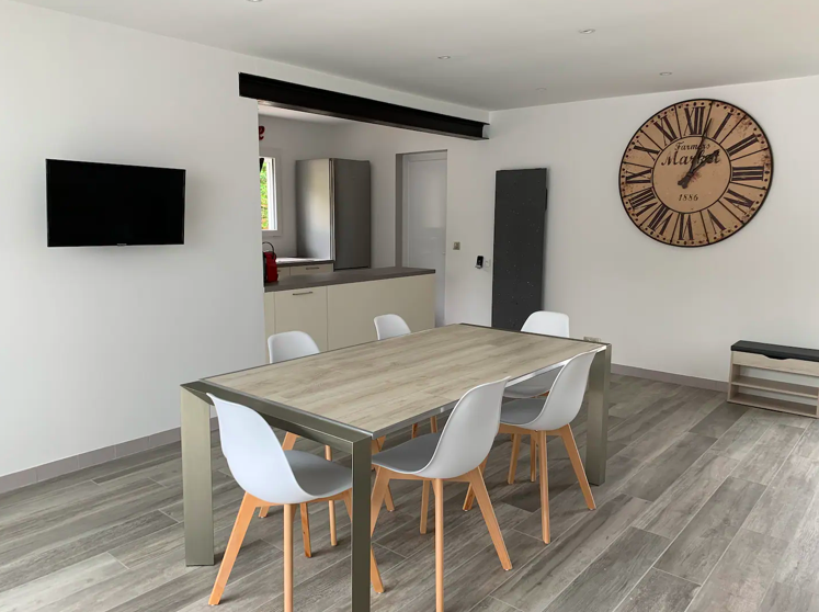 Salle à manger avec grande table et décoration contemporaine dans la maison “Le Bout au Vent”.